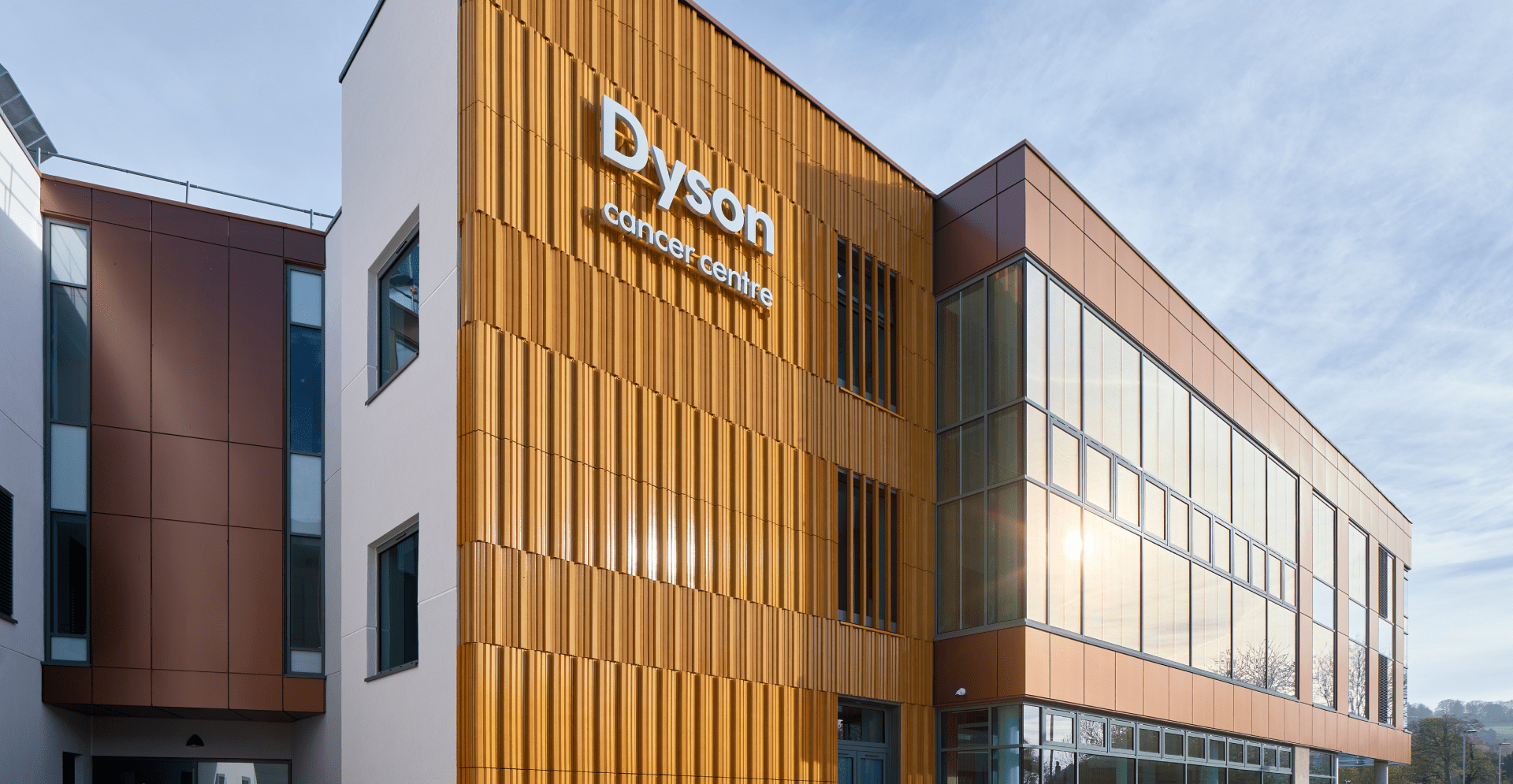 Exterior of building with large orange and brown facade, showcasing modern architecture.