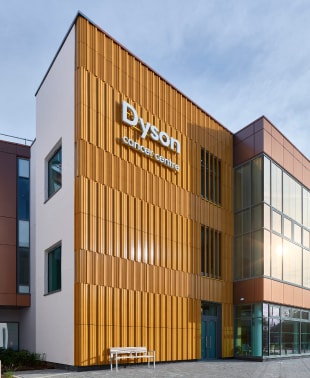 Exterior of building with large orange and brown facade, showcasing modern architecture.