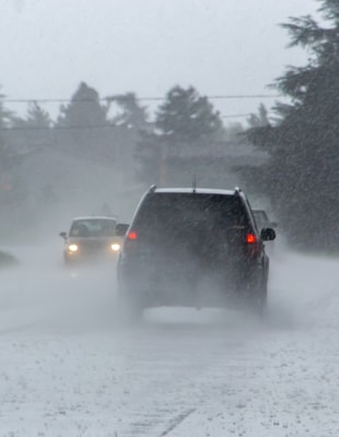 The strong storm with heavy rain on the road with poor visibility of cars. Concept of the danger of driving in bad weather