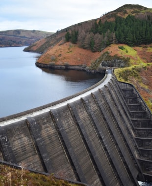 A massive dam with water cascading down, creating a powerful waterfall.