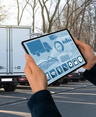 A person holding a tablet displaying a truck on the screen.
