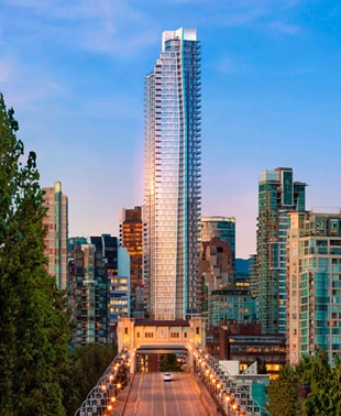 A panoramic view of the city skyline captured from a bridge, showcasing tall buildings against a clear sky.