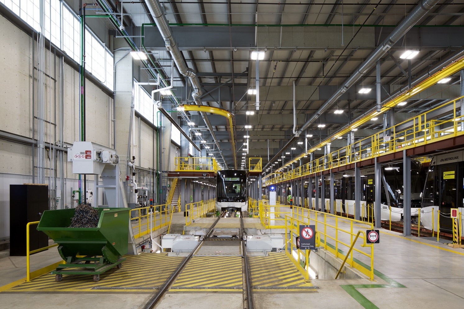A train positioned inside a factory, surrounded by machinery and industrial equipment.