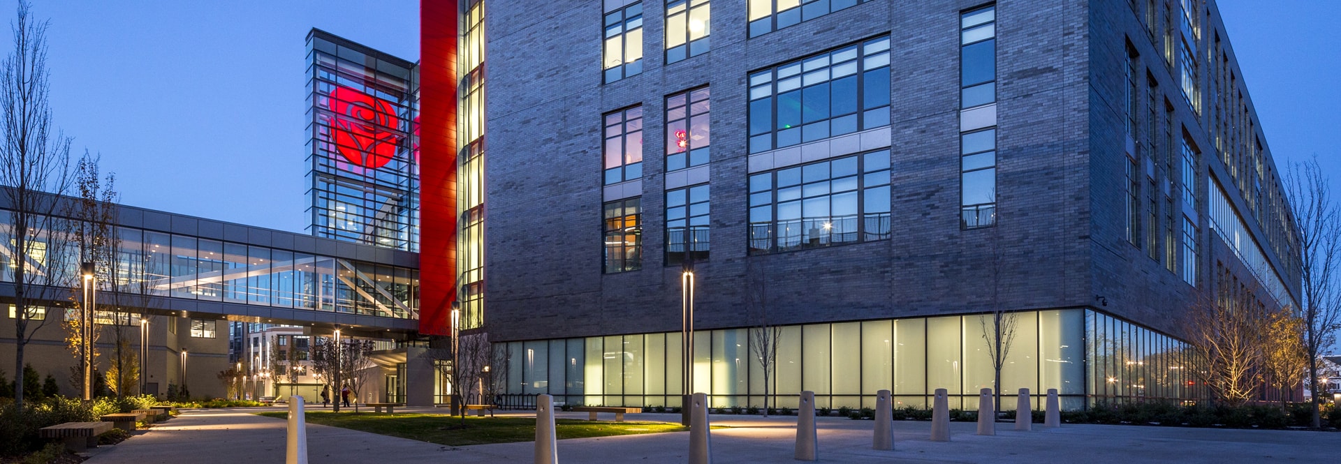 A brightly illuminated building stands out against the night sky, showcasing its architectural features in vibrant light.