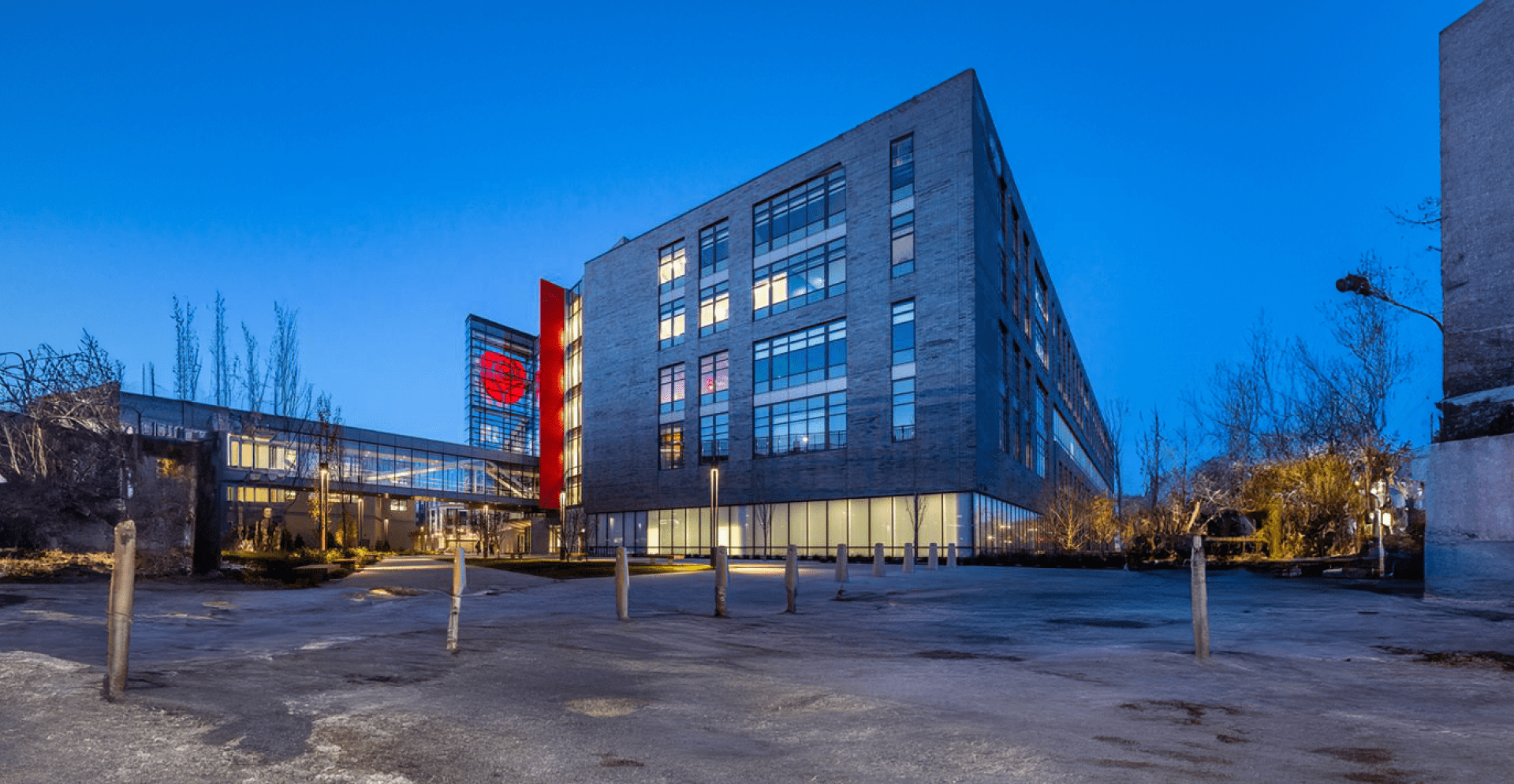 A brightly illuminated building stands out against the night sky, showcasing its architectural features in vibrant light.