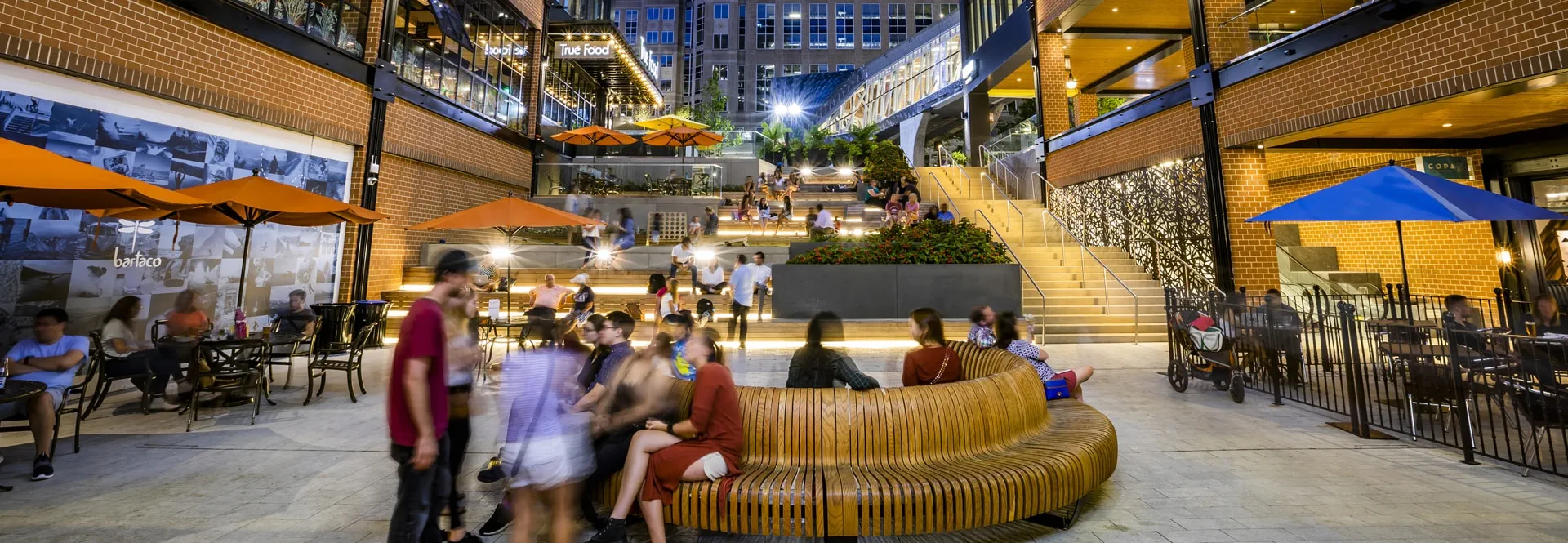 Atrium of a building with individuals seated outside, socializing.