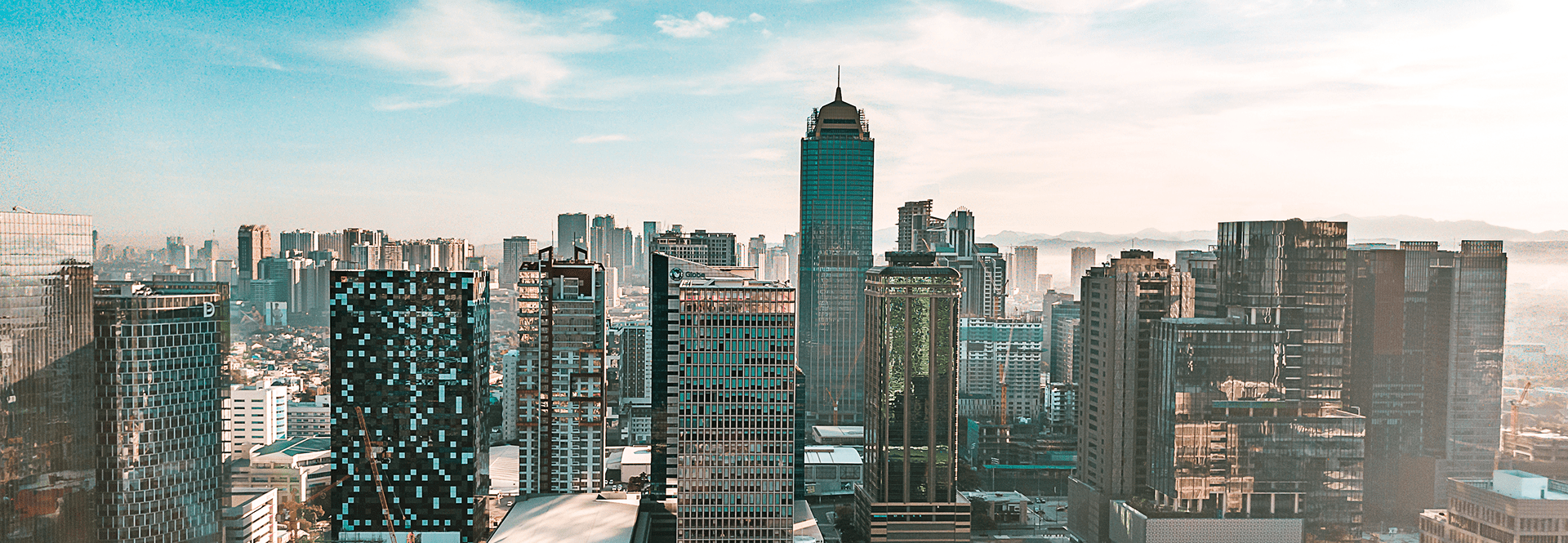 A panoramic view of a city skyline from the perspective of a high-rise building, showcasing tall buildings and urban landscape.