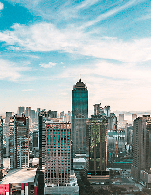 A panoramic view of a city skyline from the perspective of a high-rise building, showcasing tall buildings and urban landscape.